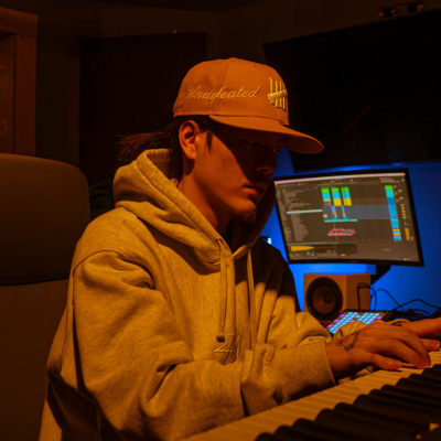 produtor musical, veste roupa de frio (moletom) e boné nas cores amarelo